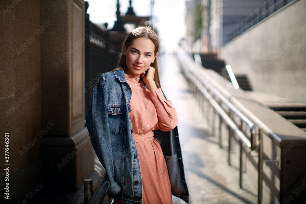 Fototapeta premium Beautiful young woman wearing dress and posing on the city street