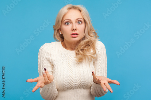 Fotografia Unhappy frustrated woman with curly blond hair spreading hands with shock and misunderstanding