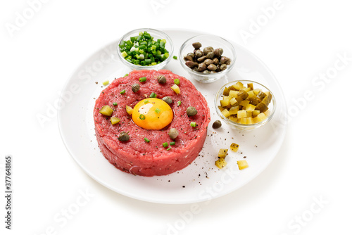 Billede på lærred Beef tartare with capers , fresh onion and pickled cucumber on white plate isolated on white background