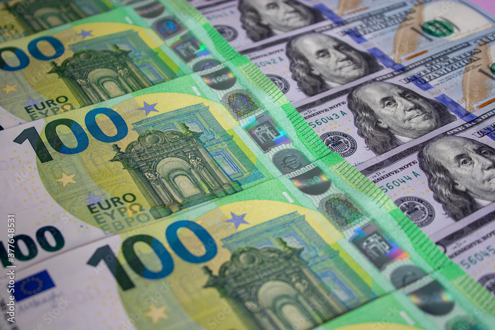 One hundred US dollars and 100 new Euros banknotes. Macro. Color image of money One hundred US dollars and 100 new Euros banknotes. Macro. Color image of money