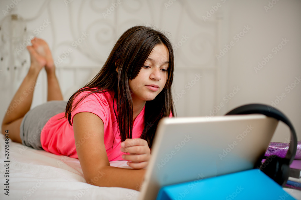 Caucasian schoolgirl with digital tablet doing school homework Caucasian schoolgirl with digital tablet doing school homework