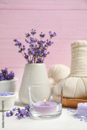 Cosmetic products and lavender flowers on white wooden table