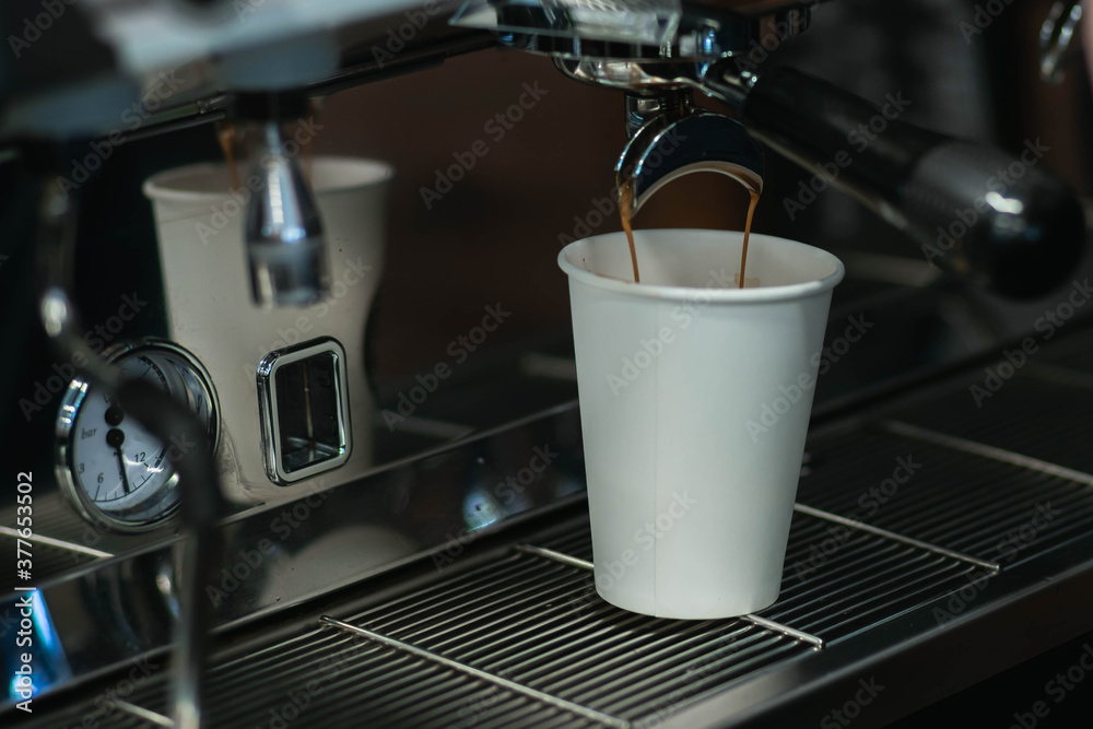 The process of making coffee on a coffee maker. The coffee is spilled from the holder into a paper cup.