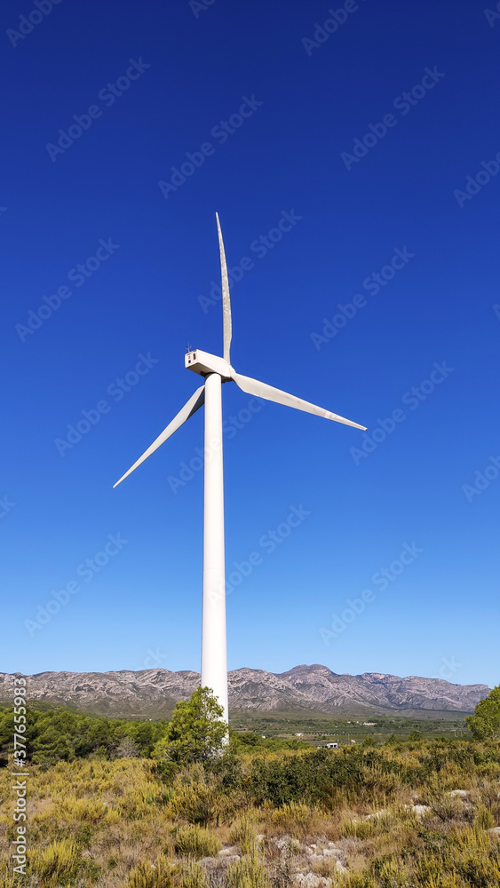 Stock photography of a large windmill in the mountain and a blue sky in the background Stock photography of a large windmill in the mountain and a blue sky in the background