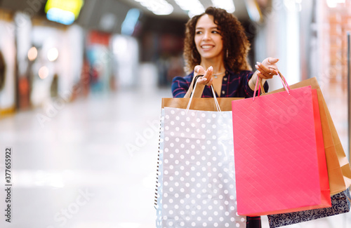 Shopping bags in the hands. Young woman with packages after shopping. Purchases, black friday, discounts, sale concept.