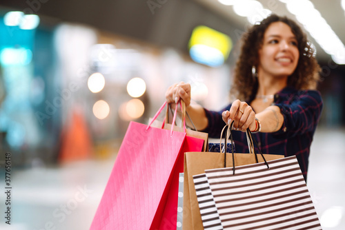 Shopping bags in the hands. Young woman with packages after shopping. Purchases, black friday, discounts, sale concept.