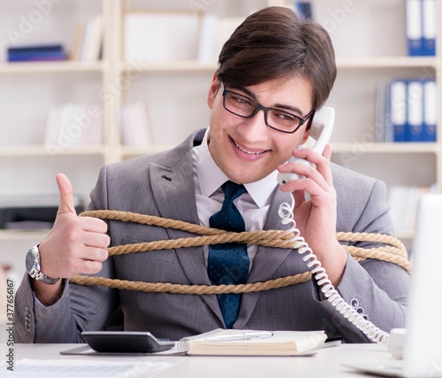 The businessman tied up with rope in office photo