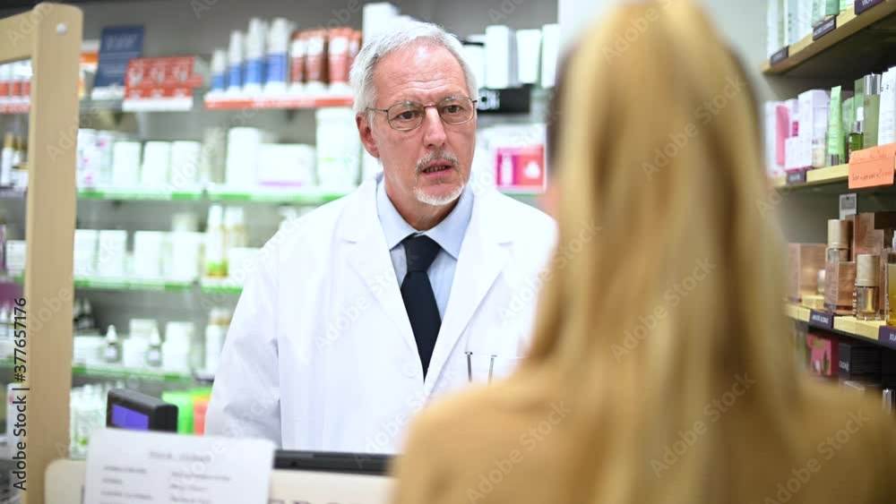 Senior pharmacist dealing with a customer