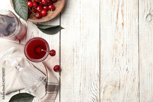 Delicious cherry wine with ripe juicy berries on white wooden table, flat lay. Space for text
