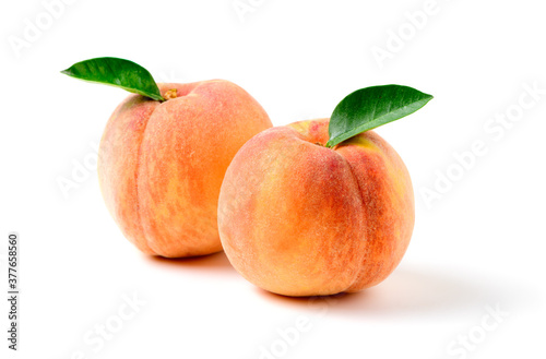 Two fresh sweet peach with green leaf isolated on white