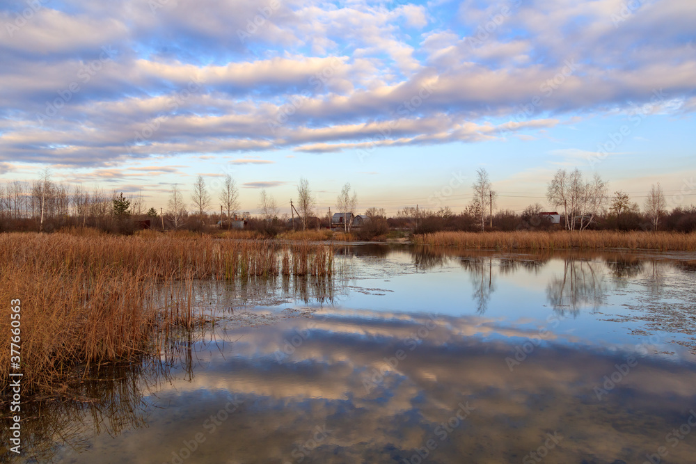 Clouds in the sky with reflection in the lake at sunset.