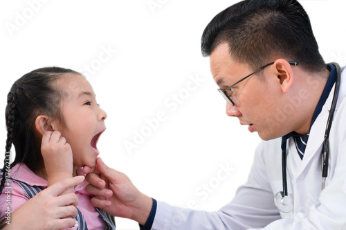 asian doctor looking at mouth of young girl who has sore throat. pediatrician and healthcare concept