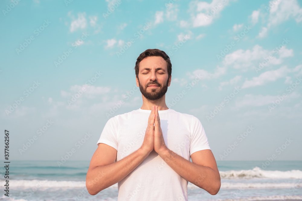 happy guy sits on the seashore and meditates. happy guy sits on the seashore and meditates.