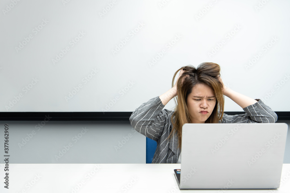 Woman working by laptop in office with annoyed Woman working by laptop in office with annoyed