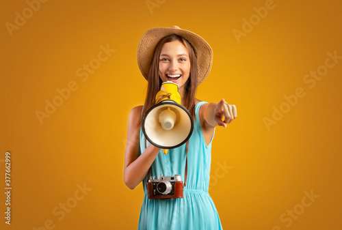 Female tourist with megaphone pointing at camera