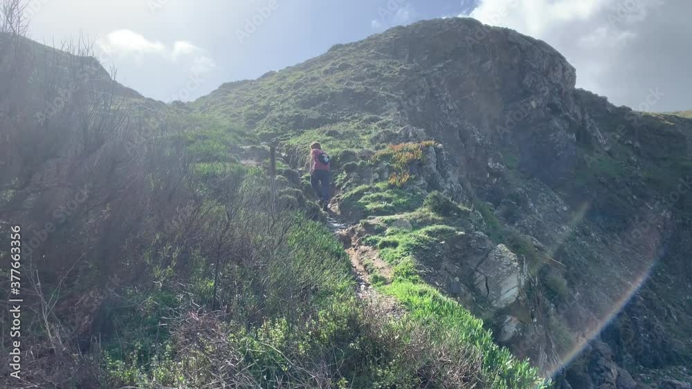 A young hiker is climbing on a hill A young hiker is climbing on a hill