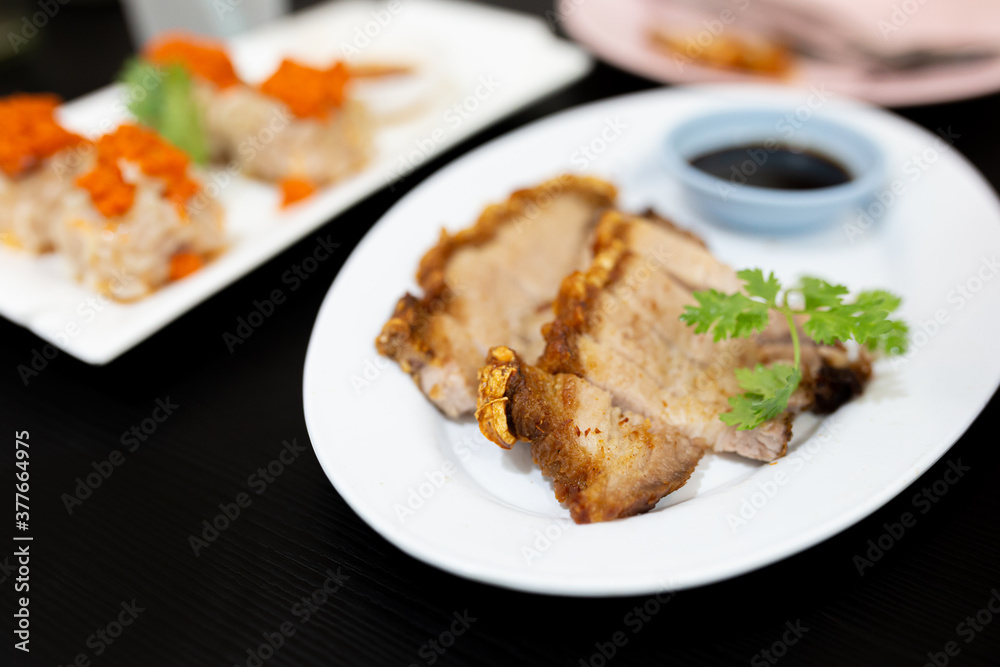 Fried pork crackling on white disk, asian food culture Fried pork crackling on white disk, asian food culture