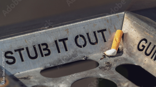 Stub it out - close up of a cigarette stub on a waste bin	
 photo