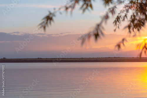 colored sunset over the river, with sky reflection