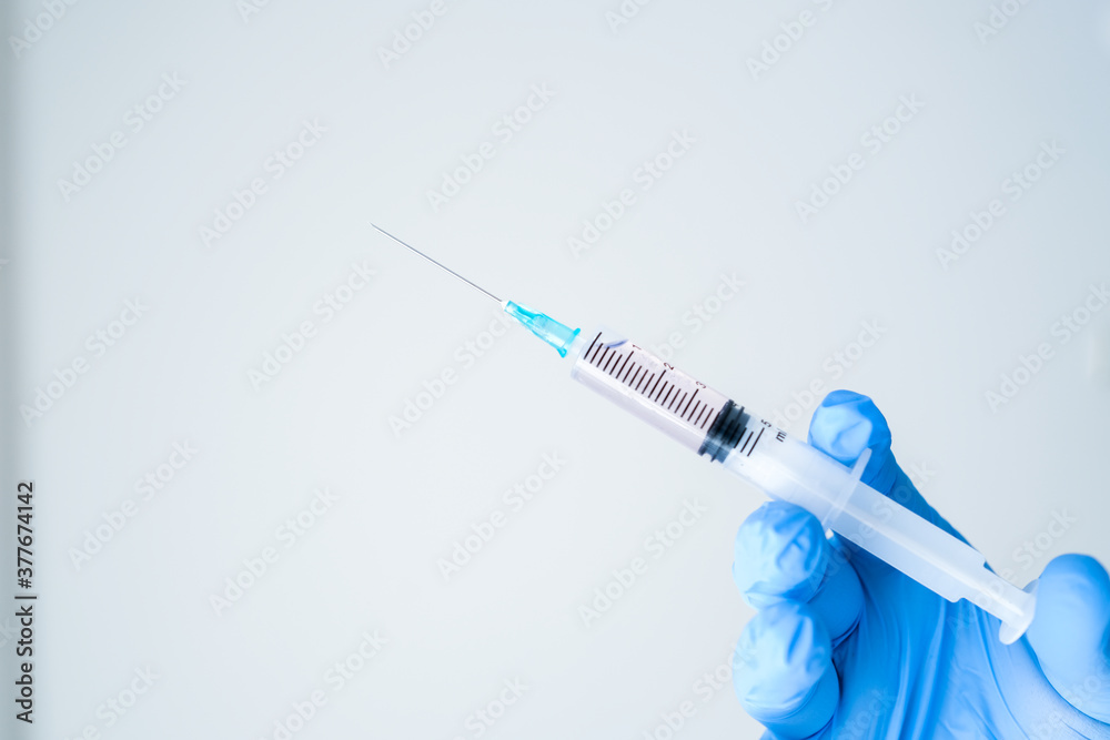 fully sheltered doctor holding syringe in hand. Young doctor preparing for vaccination. fully sheltered doctor holding syringe in hand. Young doctor preparing for vaccination.