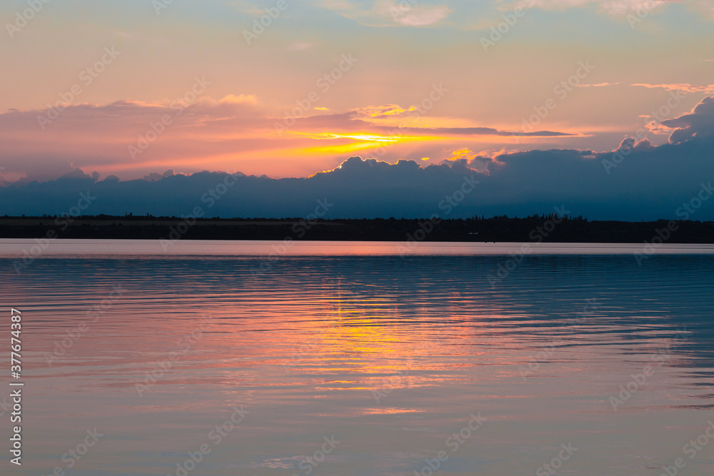 Obraz premium colored sunset over the river, with sky reflection
