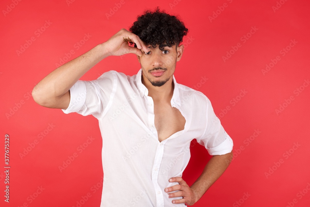 Young arab man with afro hair wearing shirt standing over isolated red background having problems, worried and stressed holds hand on forehead. Young arab man with afro hair wearing shirt standing over isolated red background having problems, worried and stressed holds hand on forehead.