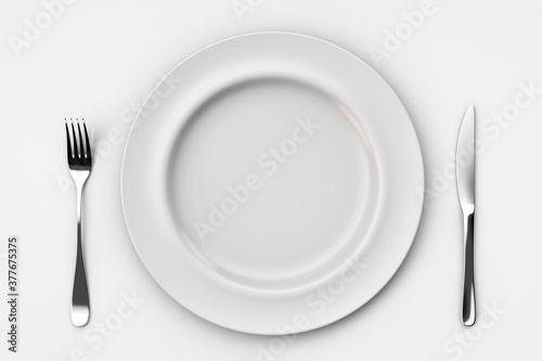 Empty white ceramic plate with fork and knife on light table. Top view.