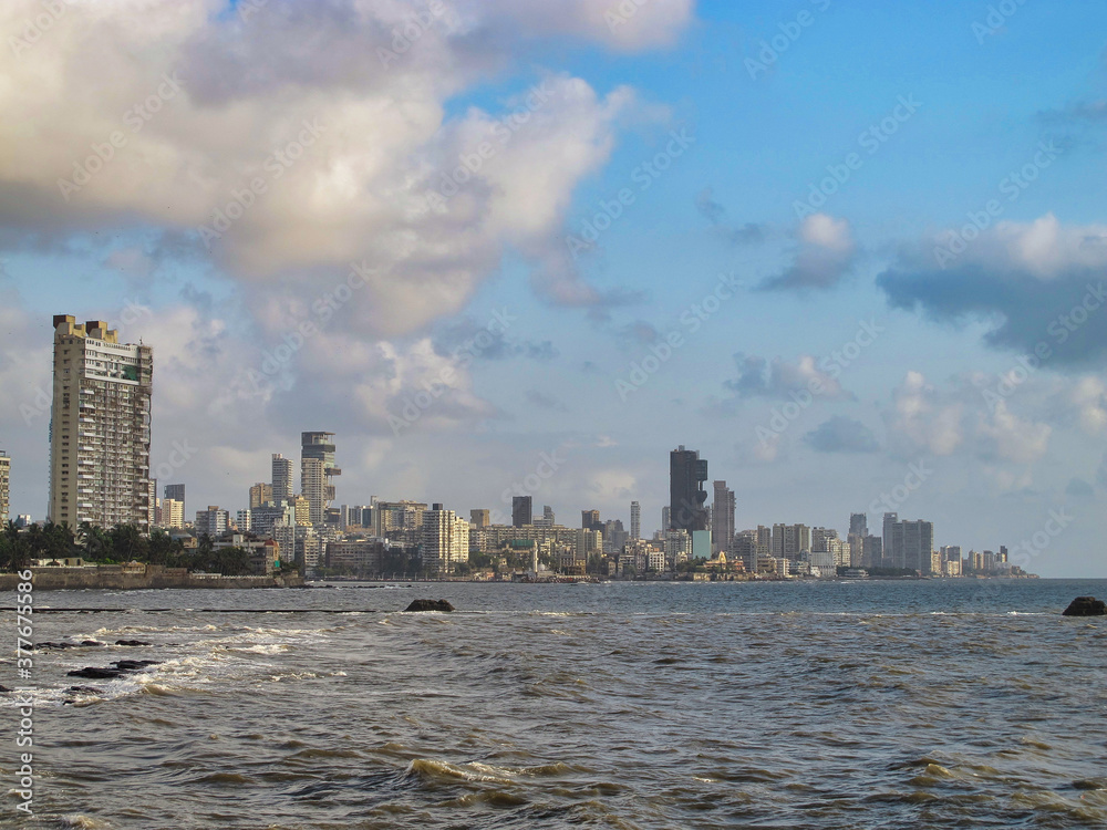 Fototapeta premium Mumbai skyline near Ocean with dramatic blue sky and clouds, India 
