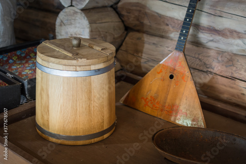 Wooden bucket with lid for food storage next to the balalaika.