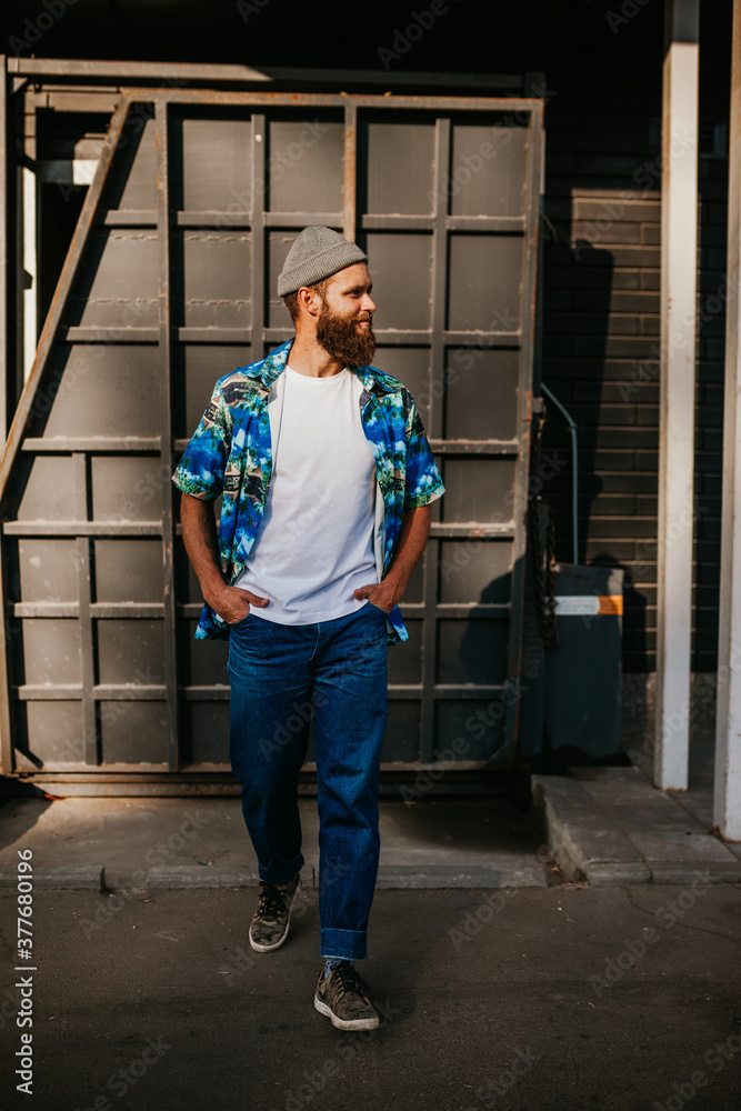 Young bearded hipster guy wearing white blank t-shirt. Mock-up for print. T-shirt template.