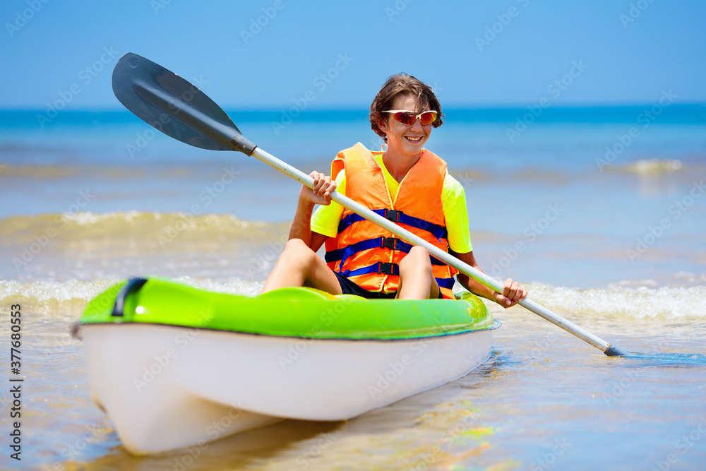 Boy on kayak in tropical sea. Kid in canoe.