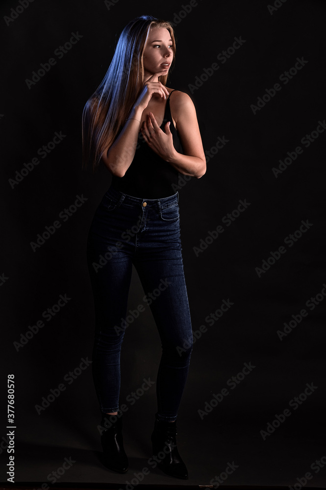 Girl on a black background in fashionable clothes Girl on a black background in fashionable clothes