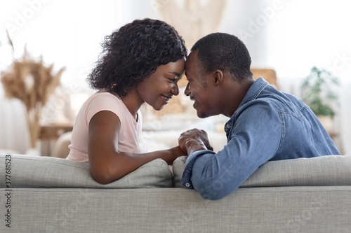 Side view of black couple in love bonding at home