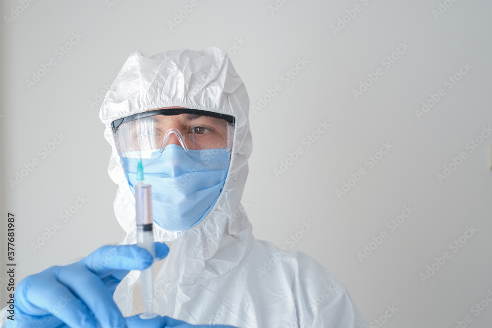 fully sheltered doctor holding syringe in hand. Young doctor preparing for vaccination.