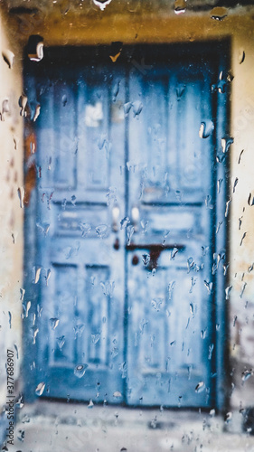 old blue door in the building with raindrops © Rohit