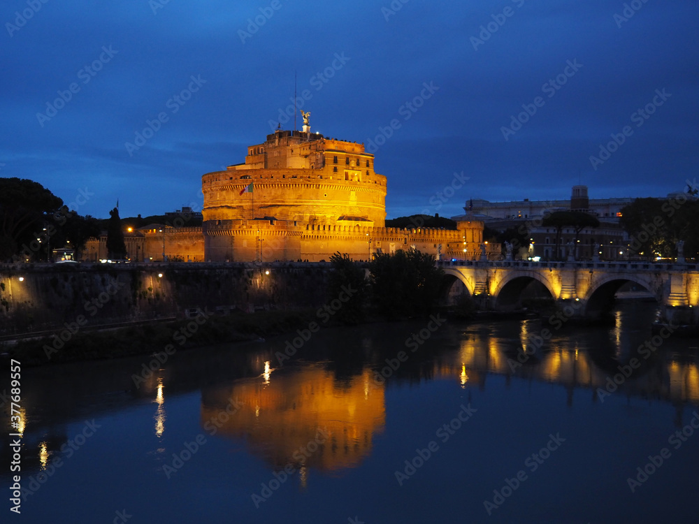 Night view of the angel's castle, the Tiber river and the bridge over it. Rome, Italy.