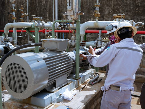 Technician checking and reading data vibration measurement of motor in power plant. photo