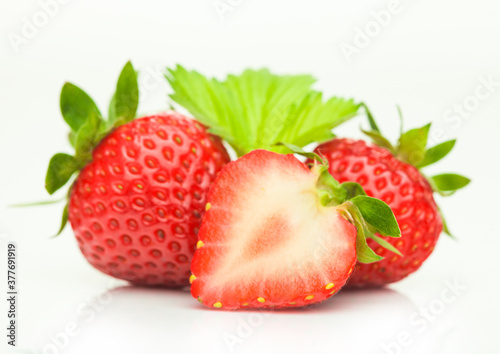 Fresh raw organic strawberries with leaf on white background.