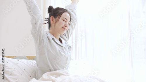 パジャマ姿の若い女性　寝起き photo