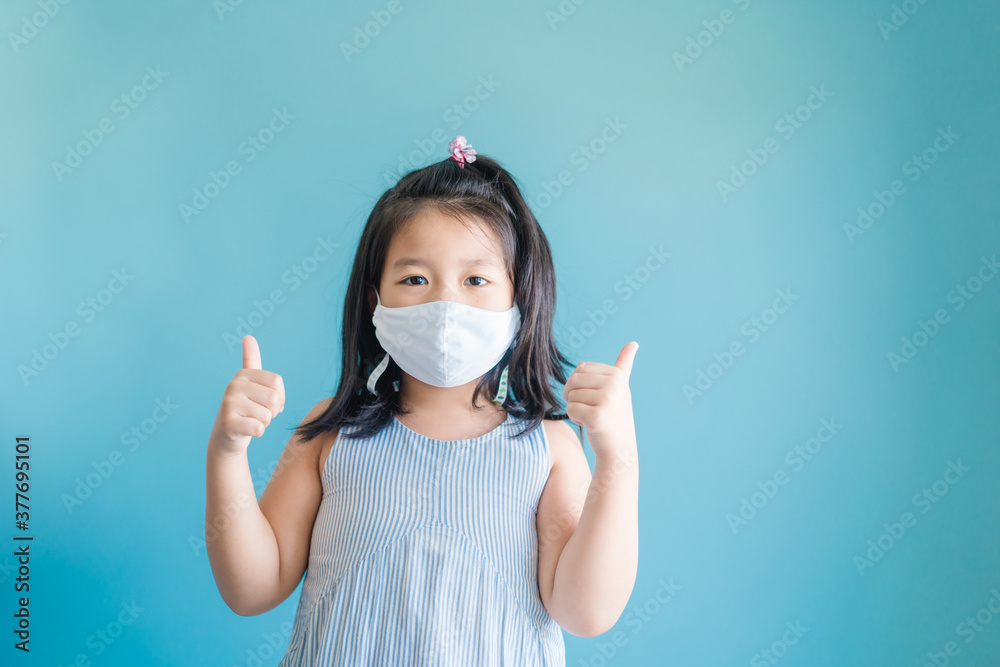 Coronavirus Covid-19.Online education at home.Asian kid girl wearing face mask show thumbs up for good and happy.Home school kid with Covid19. Online learning.Stay home.Social distancing.New normal. Coronavirus Covid-19.Online education at home.Asian kid girl wearing face mask show thumbs up for good and happy.Home school kid with Covid19. Online learning.Stay home.Social distancing.New normal.