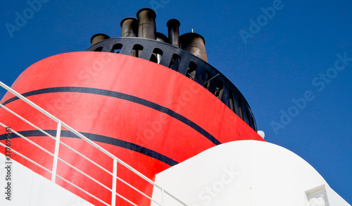 Red and black funnel of classic ocean liner or cruise ship or cruiseship against deep blue sky during ocean cruise in summer	 photo