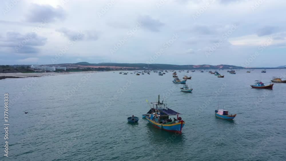 Sea aerial view on a cloudy day. Blue ocean with hundred of colourful fishing ships. Drone is following the bird upon the sea. Grey and blue colors of sky and water Sea aerial view on a cloudy day. Blue ocean with hundred of colourful fishing ships. Drone is following the bird upon the sea. Grey and blue colors of sky and water