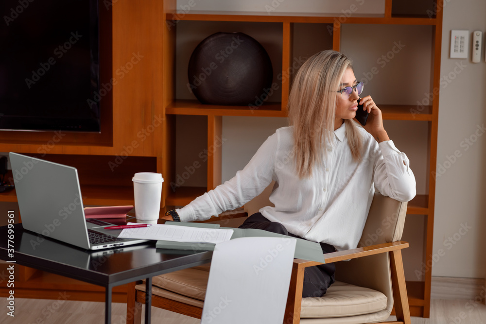 Corporate Communication. Caucasian Businesswoman Talking On Mobile Phone Working On Laptop at home