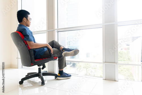 business man sitting on red chair in office