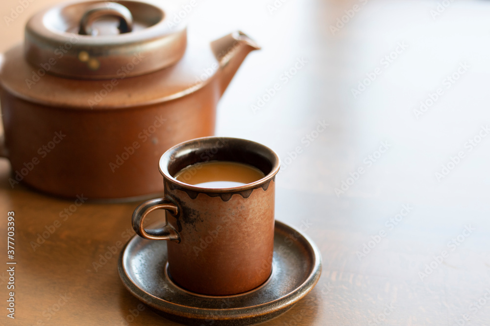 Old styled coffee cup and coffee pot on the wooden table. Coffee mug in old style Old styled coffee cup and coffee pot on the wooden table. Coffee mug in old style