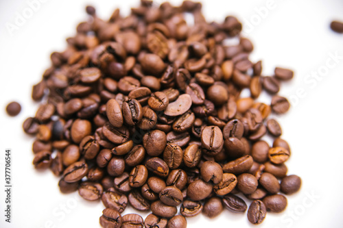 Coffee beans are scattered on a white background.