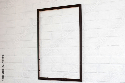 Empty blank frame on a white brick background