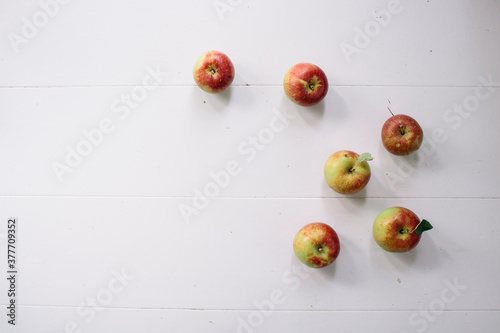 Flat-lay concept of red apples on a white wooden background  view from above  half apples