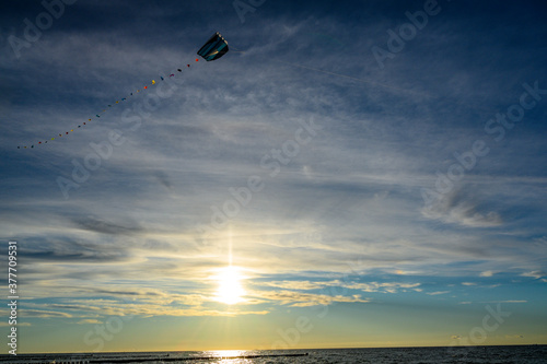Drachenfliegen im Sonnenuntergang an Strand an der Ostsee