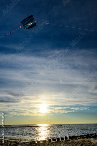 Drachenfliegen im Sonnenuntergang an Strand an der Ostsee